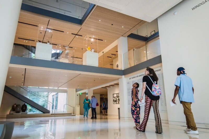 Visitors walking through the museum's bright multi-storey atrium