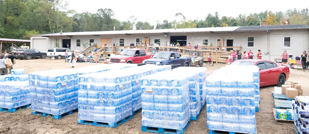 Pallets of bottled water and supplies laid out at a relief distribution site