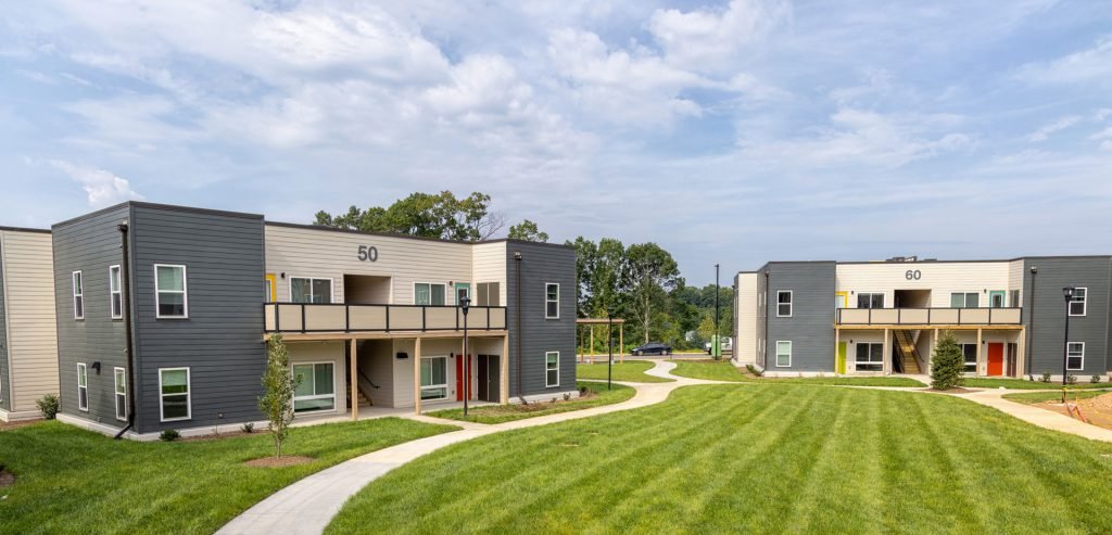 Two-storey affordable apartment buildings around a green lawn